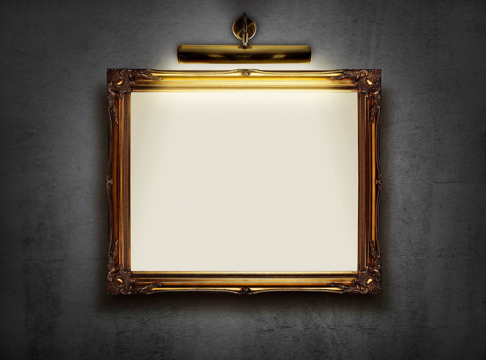 Ornate gold picture frame with spotlight on dark wall