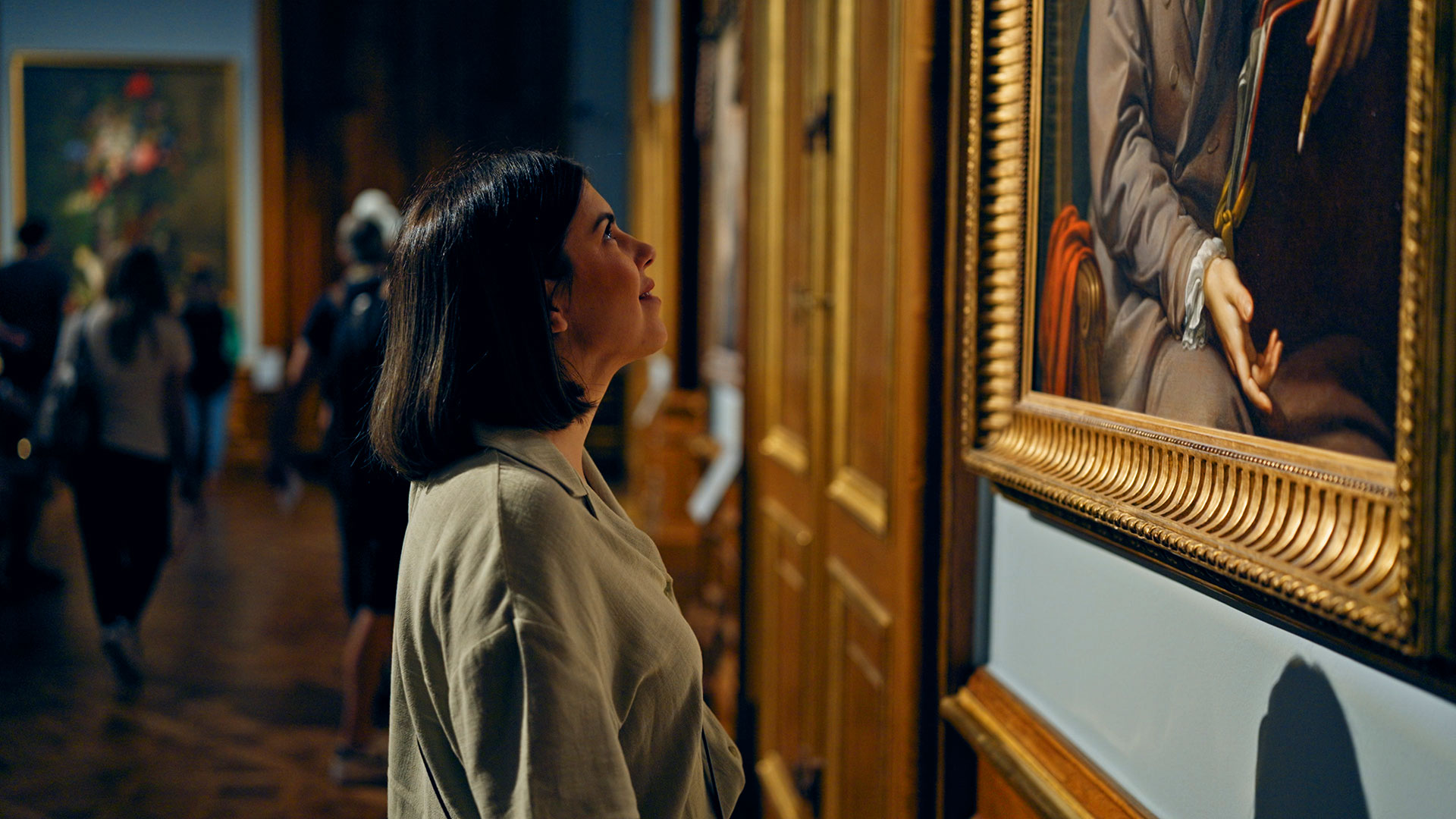 Woman looking at a framed painting on display in an art gallery